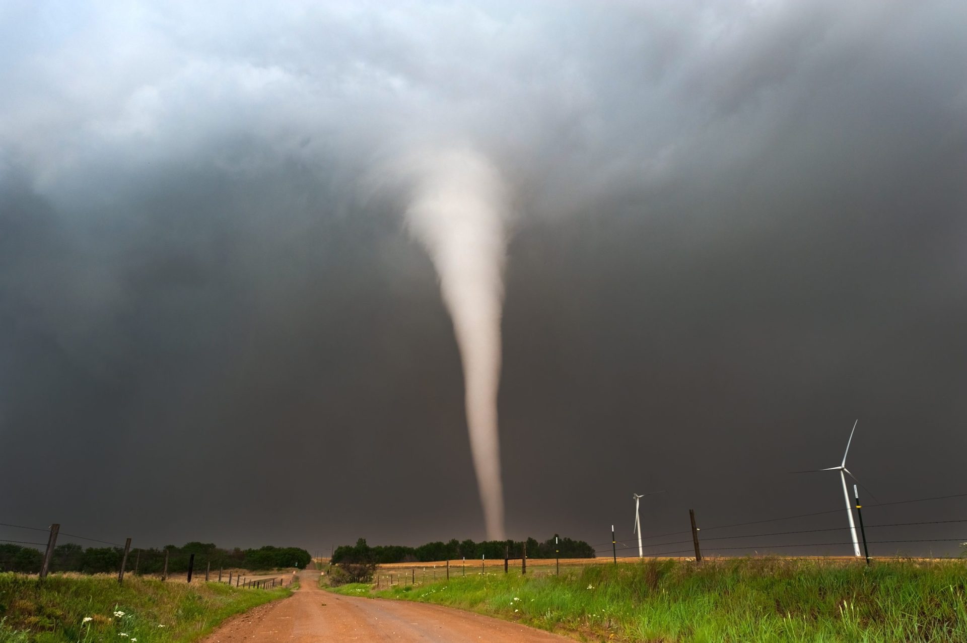 Homem corta a relva durante um tornado